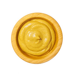 Mustard sauce in wooden bowl isolated on white background. Top view