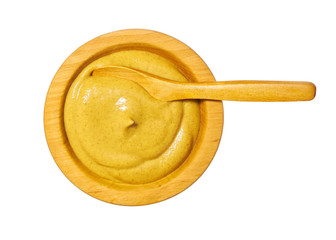Mustard sauce in wooden bowl isolated on white background. Top view