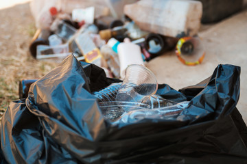 garbage bottle in black plastic bag