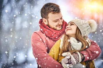 Happy Young Couple in Winter Park laughing and having fun. Family Outdoors.