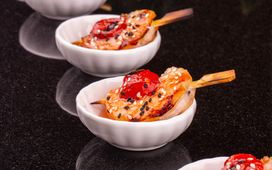 A shrimp with tomatoes on a grill