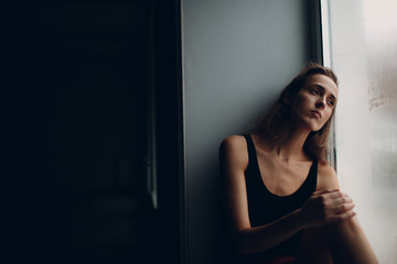 Portrait of young beautiful woman near misted window