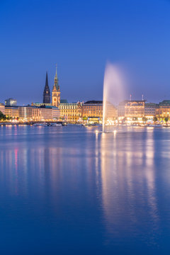 The Inner Alster Lake (German: Binnenalster) in Hamburg, Germany. View of the inner city at dusk with the fountain reflecting in the water.