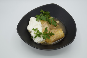cabbage stuffed with rice and meat on plate with yogurt