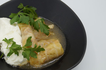 cabbage stuffed with rice and meat on plate with yogurt