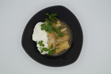 cabbage stuffed with rice and meat on plate with yogurt