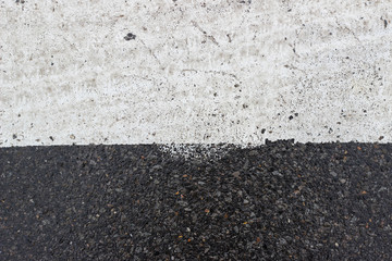 Fototapeta premium Asphalt pavement sign marking crosswalk white paint wet old surface texture detail
