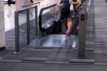 Fototapeta na wymiar People standing on escalators in airports.