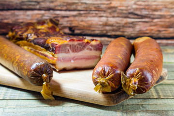 Homemade sausage and bacon on wood background