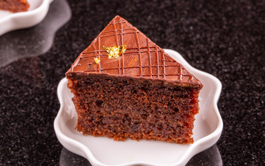 A brown chocolate biscuit with gold and chocolate