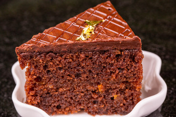 A piece of a chocolate biscuit with milk chocolate and nuts 