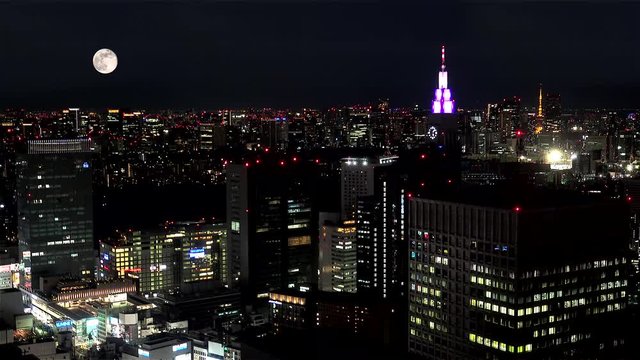 Full moon on the Tokyo skyline  from the Metropolitan Government Building. Shinjuku, Tokyo, Japan