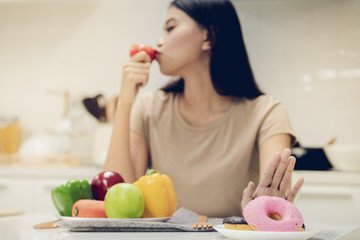 Young beautiful woman take care her health by eating salad and fruit instead of eating fat and calories