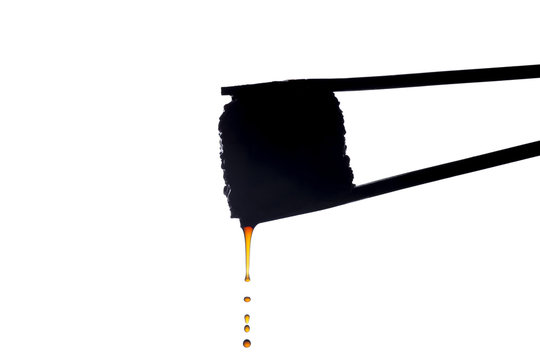 recommend clip art: sushi silhouette with drops of sauce flowing down on white isolated background, roll between chopsticks, food background, Japanese cuisine