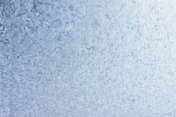 Frozen winter window pane coated shiny icy patterns. Frost background, closeup. Extreme north low temperature. Natural ice glass