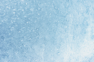 Frozen winter window pane coated shiny icy patterns. Frost background, closeup. Extreme north low temperature. Natural ice glass