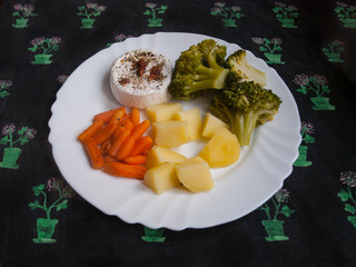 Grilled camembert with chilli on white plate with potatoes, carrots and broccoli. Tasty lunch prepared for vegetarian.