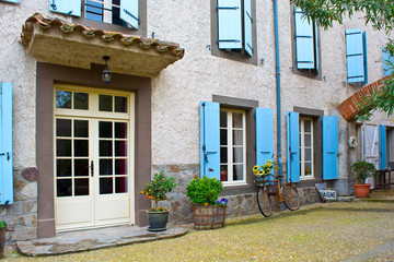 Entrance to old house with blue windows in a French street