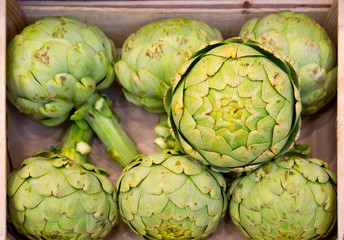 wooden box full of artichokes in french food market
