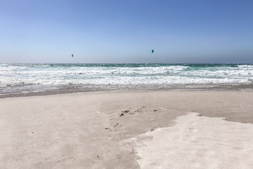 Fototapeta na wymiar Kitesurfing or kiteboarding in the sea foam. Big wave break spray in the ocean
