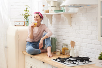 Young woman drinking a morning coffee in kitchen
