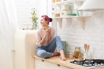 Young woman drinking a morning coffee in kitchen
