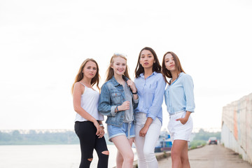 Happy group of female friends looking at camera and smile. Young girl student after College