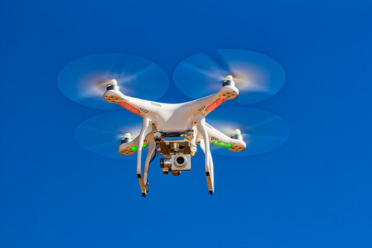 drone with camera flying with blue sky in the background