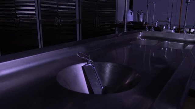 AUTOPSY TABLE WITH A BONE SAW ATOP.  LOW ANGLE SLIDER SHOT IN 4K, 10 BIT.