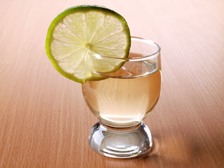Glass cup with tequila on table