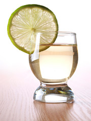 Glass cup with tequila on table