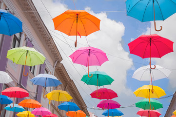 Fototapeta na wymiar Colorful umbrellas against the sky in city