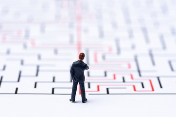 Miniature people, businessman in the labyrinth or maze figuring out the way out. Business concept,...