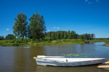 Naklejka na ściany i meble Boat on river at beautiful summer day.