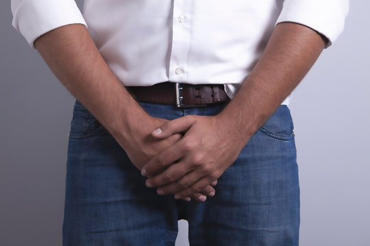 man covers groin