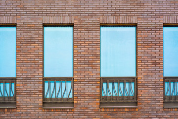 Brick wall of a building with a window and metal bars