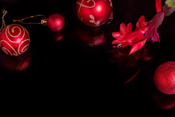 Christmas background with a red ornament and ribbon on a black background