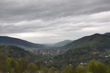 Panoramic view of the mountains. Ukrainian Carpathians view of the mountains and the city between them. Clouds over a mountain village in the Carpathians.