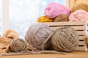 Woolen yarn and fabric on the window sill. Beautiful view outside the window - winter scenery and...