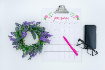 January calendar overhead view with glasses and smartphone