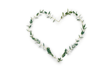 Fototapeta na wymiar Green leaves in a shape of heart on white background with copy space