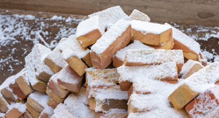 pile of building bricks in the winter under the snow