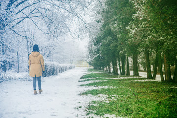 woman walk by park where winter meet spring