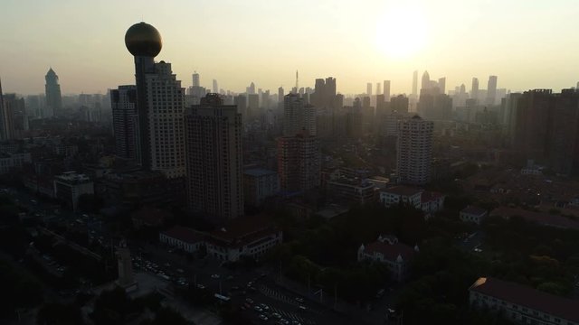 Panoramic drone shot of futuristic Howard Johnson hotel complex and modern skyline of Wuhan city at sunset, architecture and urban development in China