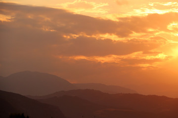 Obraz premium Magiczny pomarańczowy zmierzch w górach.