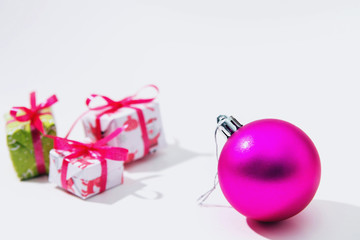 Pink ball and three gifts on a white background