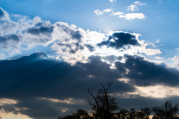 Fototapeta na wymiar Blue Sky with Sun Rays and Clouds