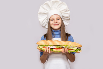 Happy little girl with hot dog and chef uniform isolated on white background.