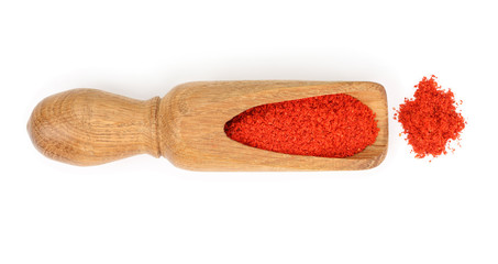 sweet paprika spice in a wooden spoon isolated on white background. Top view. Flat lay