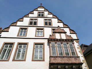 Schönes altes Kaufmannshaus mit Erker und restaurierter Fassade vor blauem Himmel im Sonnenschein...